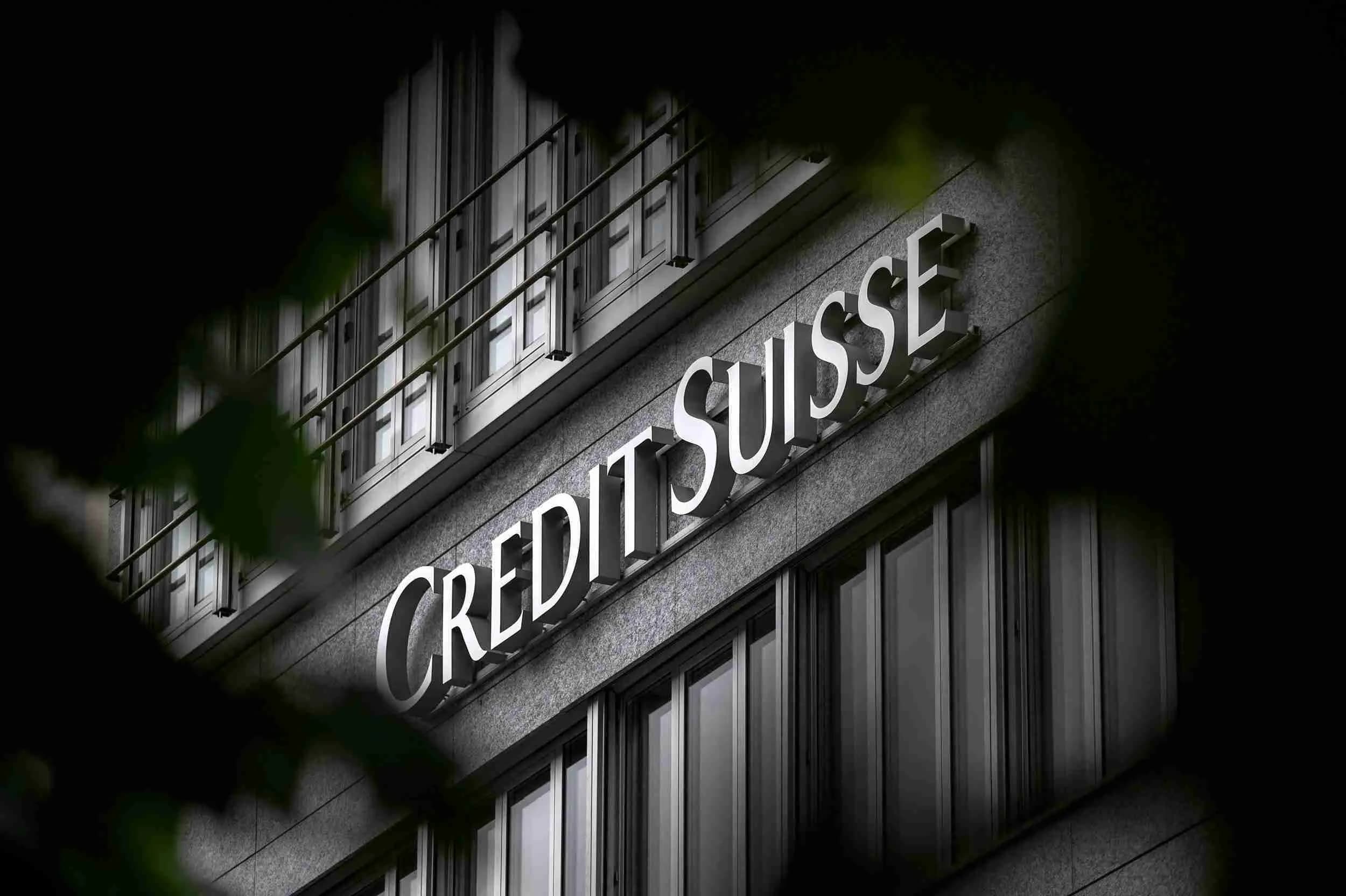 Photo du siège de la banque suisse Credit Suisse, avec des drapeaux suisses et européens flottant au vent.